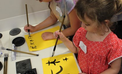 Children doing calligraphy at Explorama